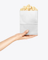 Paper Package w/ Popcorn in a Hand Mockup