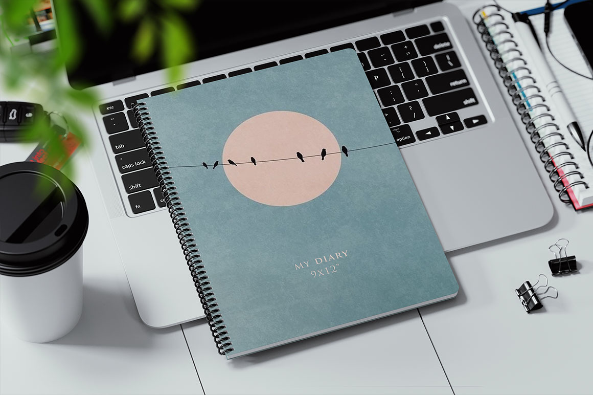Coil Bound Book on a Laptop Keyboard Mockup Coil Bound Book on a Laptop Keyboard Mockup