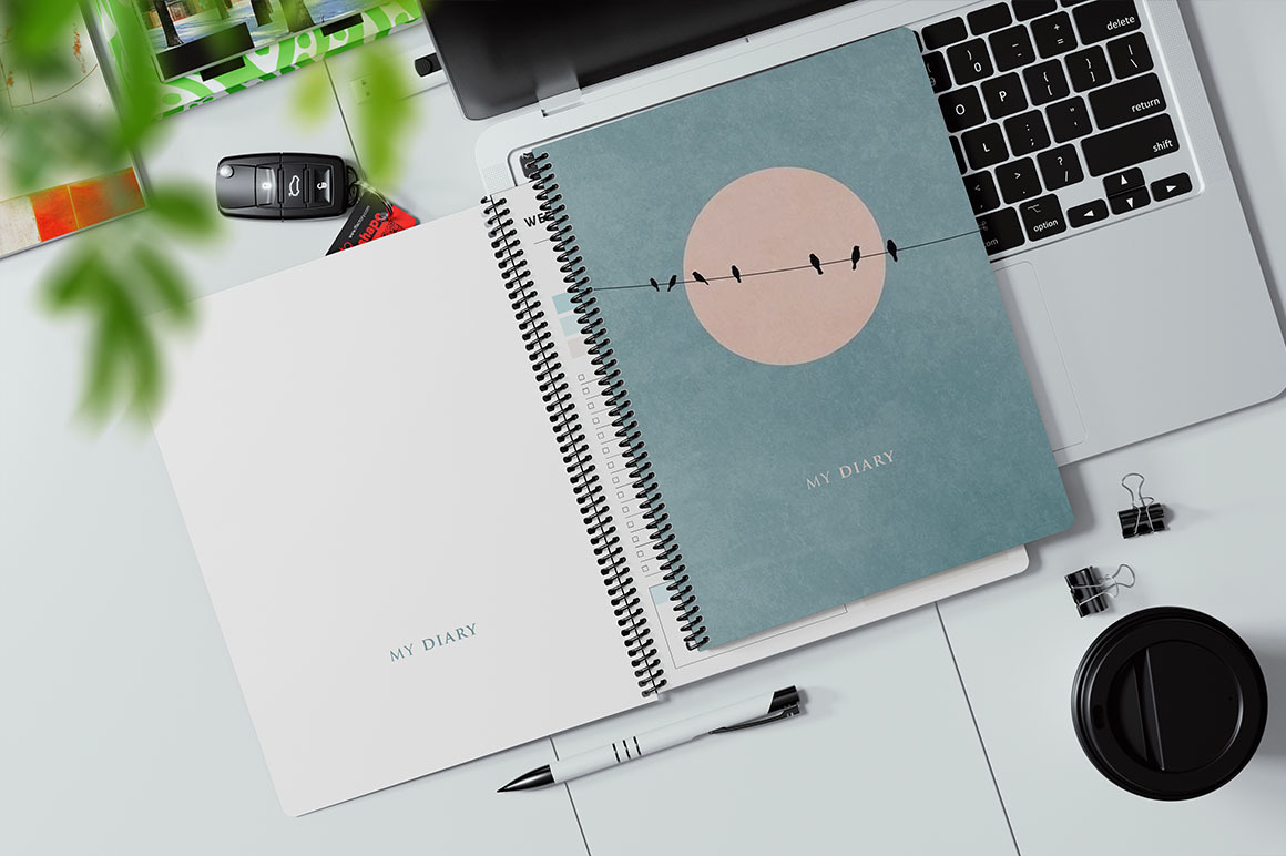 Coil Bound Book on a Laptop Keyboard Mockup Coil Bound Book on a Laptop Keyboard Mockup