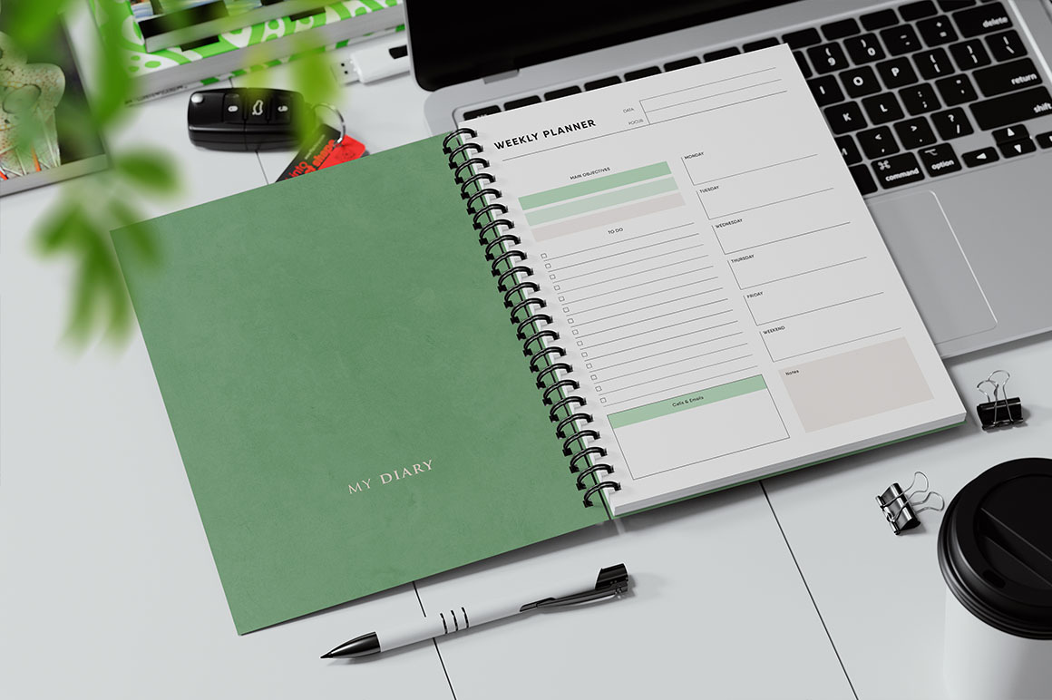 Spiral Bound Book on a Laptop Keyboard Mockup Spiral Bound Book on a Laptop Keyboard Mockup