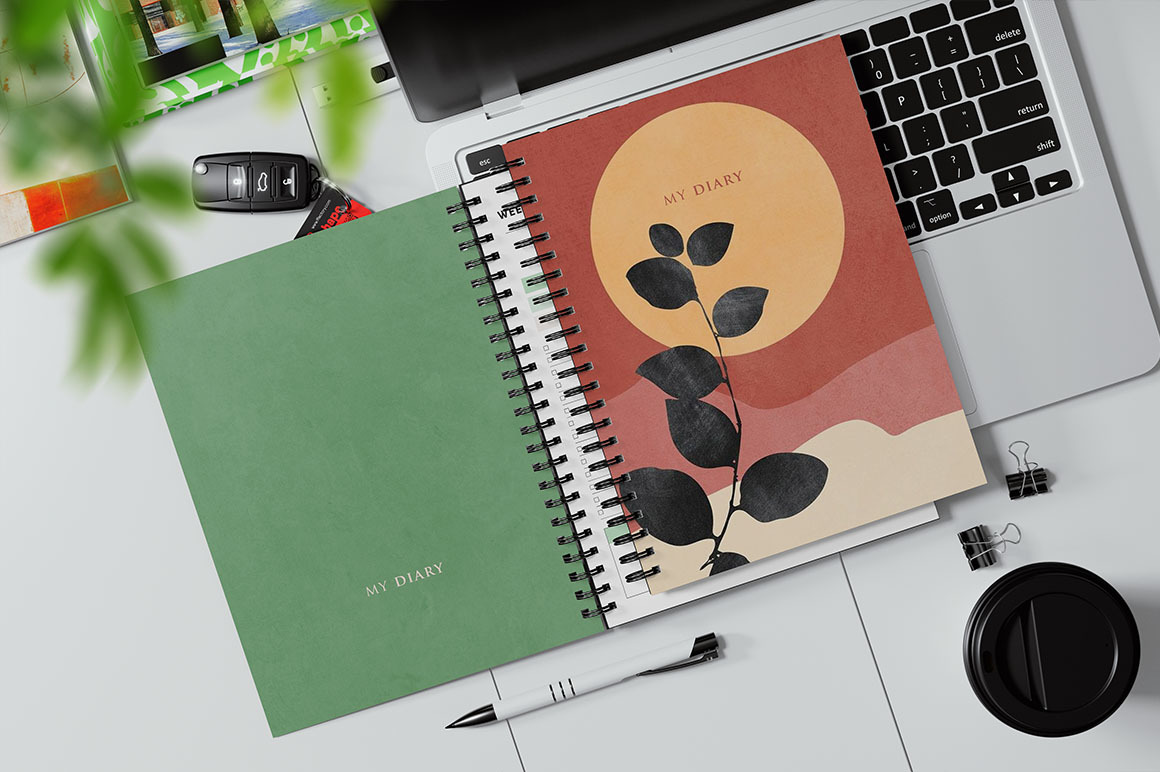 Spiral Bound Book on a Laptop Keyboard Mockup Spiral Bound Book on a Laptop Keyboard Mockup