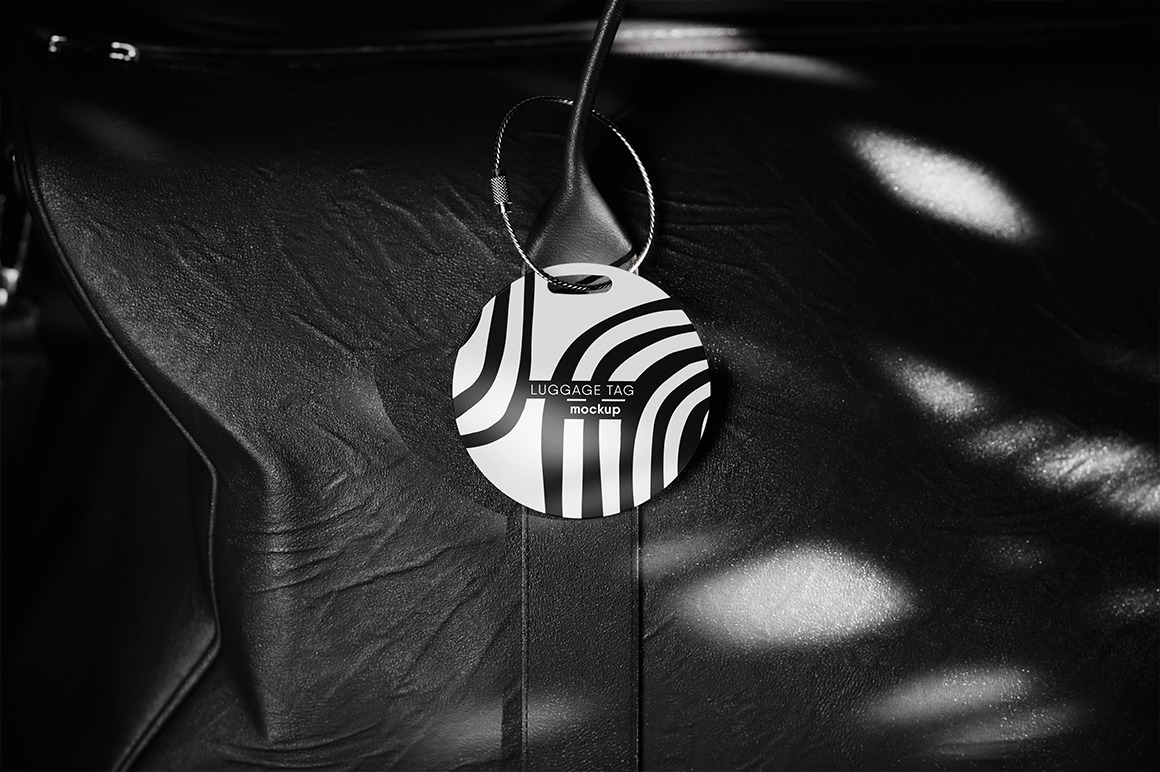 Round Luggage Tag Hanging on a Leather Bag Mockup Round Luggage Tag Hanging on a Leather Bag Mockup