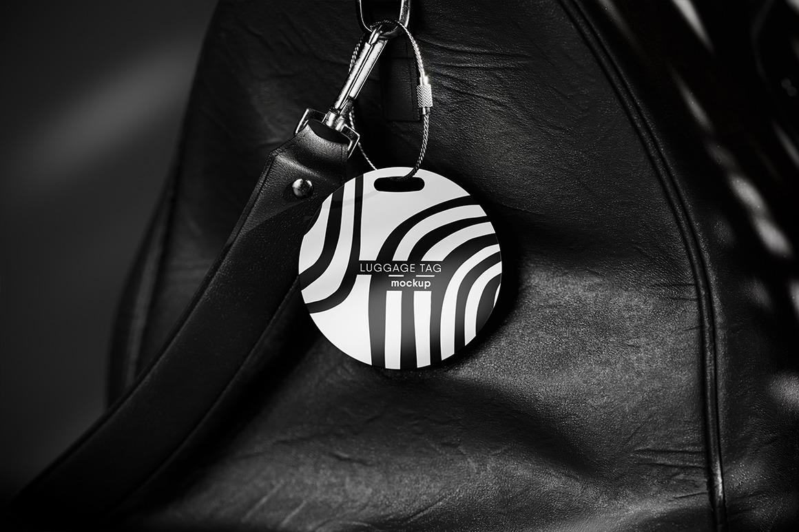Round Luggage Tag Hanging on a Leather Bag Mockup Round Luggage Tag Hanging on a Leather Bag Mockup