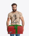 Bearded Man Wearing a Tight Fit T-Shirt Holds a Gift Box Mockup