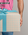 Bearded Man Wearing a Tight Fit T-Shirt Holds a Gift Box Mockup