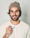 Man Wearing a T-Shirt and Beanie Hat Holding a Button Pin Mockup