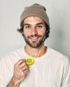 Man Wearing a T-Shirt and Beanie Hat Holding a Button Pin Mockup
