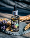 Oil Tincture Dropper Bottle on a Stone Plate with Herbs Mockup