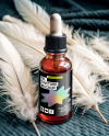 Ruby Oil Tincture Dropper Bottle with Feathers on Fabric Mockup
