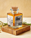 Orange Oil Tincture Square Bottle on a Wooden Board with Herbs Mockup