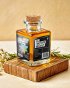 Orange Oil Tincture Square Bottle on a Wooden Board with Herbs Mockup