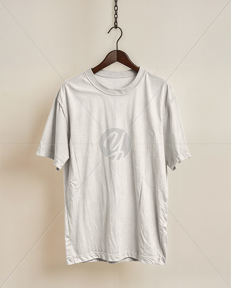 T-Shirt on a Wooden Hanger Against a Plain Background Mockup