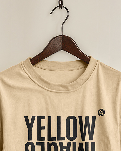 T-Shirt on a Wooden Hanger Against a Plain Background Mockup