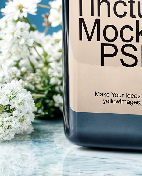 Dark Amber Oil Tincture Square Bottle on a Marble Surface with Flowers Mockup