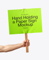 A Hand Holding a Paper Sign with Wooden Handle Mockup