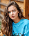 Young Woman in Sweatshirt Sitting on Hay Block Next to Wooden Wall Mockup