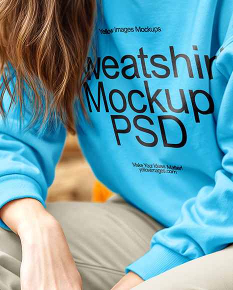 Young Woman in Sweatshirt Sitting on Hay Block Next to Wooden Wall Mockup