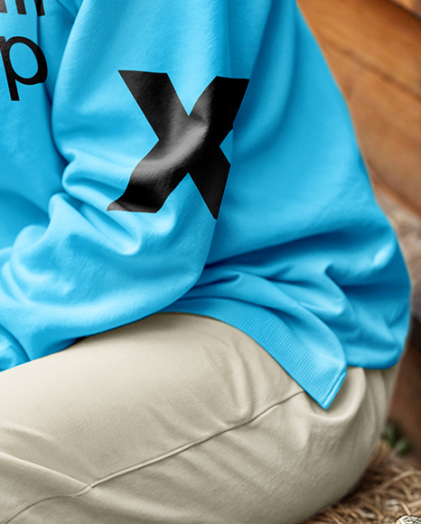 Young Woman in Sweatshirt Sitting on Hay Block Next to Wooden Wall Mockup
