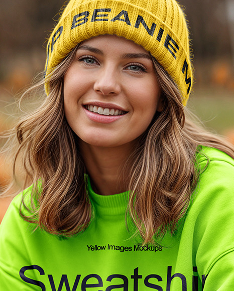 Young Woman in Sweatshirt and Beanie Sitting Next to Pumpkins Mockup